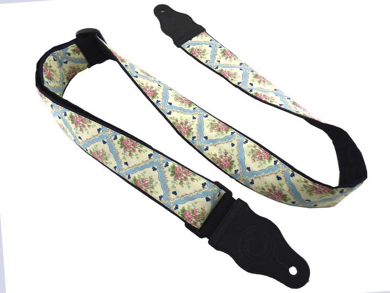 Square guitar strap with flowers.  Pink flower buds black